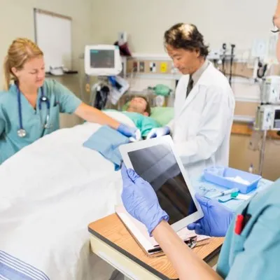 A doctor holding a tablet computer in a hospital room, using technology to enhance patient care