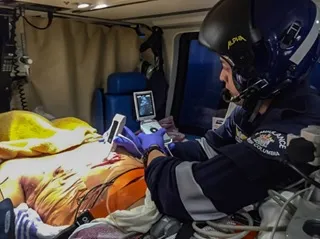 a man in a motorcycle helmet sitting on a bed