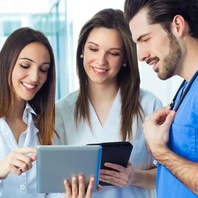 a group of doctors looking at a tablet computer screen