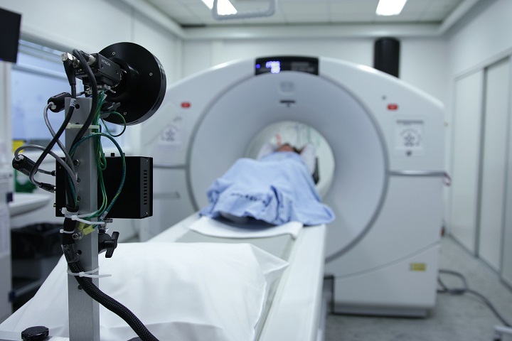 a hospital room with a mri machine in the background