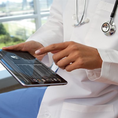 a person in a white lab coat holding a tablet computer